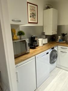 a kitchen with a washing machine and a microwave at LA MARIEFACTURE - Comme Chien et Chat in Saint-Avold