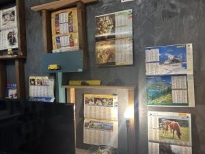 eine Wand mit Kalendern und einem TV in einem Zimmer in der Unterkunft LA MARIEFACTURE - Comme une Lettre à la Poste in Neuf-Brisach