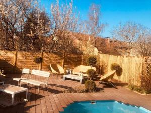 a patio with chairs and a pool and a fence at LA MARIEFACTURE - Comm chez Mémé in Laning