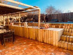 a patio with a wooden fence and a table at LA MARIEFACTURE - Comm chez Mémé in Laning