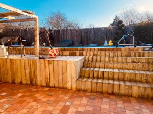 a wooden fence with steps next to a pool at LA MARIEFACTURE - Comm chez Mémé in Laning +2 photos
