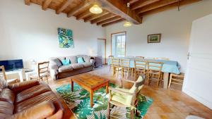 ein Wohnzimmer mit einer Couch und einem Tisch und Stühlen in der Unterkunft Gite Les Fragonnettes in Saint-Julien-des-Landes
