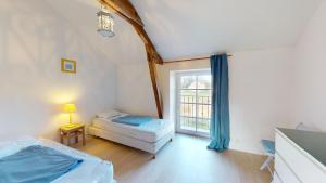 ein Schlafzimmer mit zwei Betten und einem Fenster in der Unterkunft Gite Les Fragonnettes in Saint-Julien-des-Landes