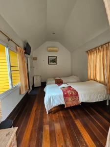 1 dormitorio con 2 camas y suelo de madera en Baan Rai Somkiat Homestay Saraburi, en Ban Lam Thong Lang