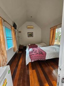 1 dormitorio pequeño con 1 cama y suelo de madera en Baan Rai Somkiat Homestay Saraburi, en Ban Lam Thong Lang