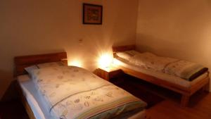 Duas camas individuais num pequeno quarto com luz. em Hase em Eslohe