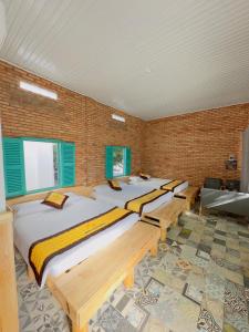 a bedroom with four beds in a brick wall at Ninh Chu 2 Hotel in Phan Rang
