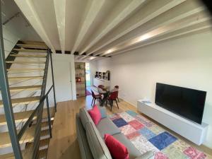 a living room with a couch and a tv and a staircase at Exclusive house in Marostica in Marostica