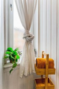 a window with a curtain and a chair in a room at Traditional 1-Bed Flat in Southside (Hampden/Shawlands) in Glasgow