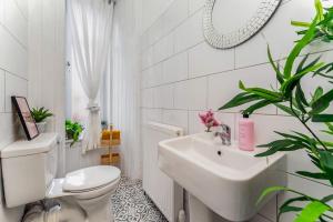 a white bathroom with a toilet and a sink at Traditional 1-Bed Flat in Southside (Hampden/Shawlands) in Glasgow +7 photos