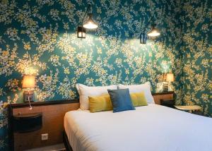 Villa Pruly Hotel Cannes Centre في كان: غرفة نوم مع سرير وورق جدران