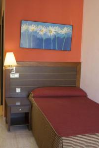 En eller flere senge i et værelse på Hotel la Parrilla