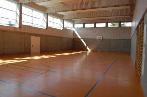 un gimnasio vacío con una cancha de baloncesto en un edificio en Ferienwohnungen JHS en Seewis im Prättigau