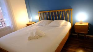 - une chambre avec un lit et 2 serviettes dans l'établissement Très joli T2 cosy et calme, Butte aux Cailles, à Paris