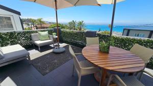 a patio with a table and chairs and an umbrella at Mosselbay Dream Home in Mossel Bay