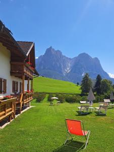 a red chair sitting in the grass next to a house at Kachlerhof in Castelrotto