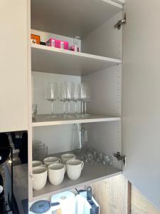 a shelf with bowls and wine glasses on it at Apartmány nad Anenským potokem - Říčky in Říčky