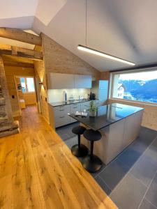a kitchen with a counter and a table with stools at Ferienwohnungen JHS in Seewis im Prättigau