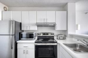 a white kitchen with a stove and a microwave at Streeterville Studio w Gym Pool nr Navy Pier CHI-450 in Chicago