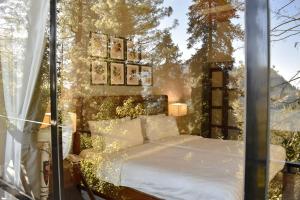 a bedroom with a bed in a window at Lemon Lodges By Roomy, Nathiagali in Nathia Gali