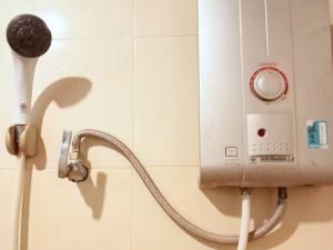 una ducha con una manguera conectada a un cabezal de ducha en Bank Guesthouse, en Haad Rin