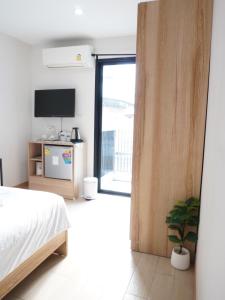 a bedroom with a bed and a sliding glass door at ATC Residence in Bang Su