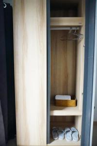 a cupboard with a bed and two pairs of shoes at ATC Residence in Bang Su
