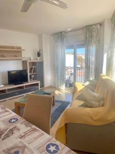 un soggiorno con un divano e una TV di El Faro a Jávea