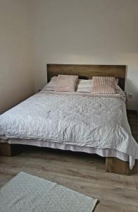 a bed with a wooden headboard in a bedroom at Yvett Studio-Fortuna Park in Sfântu-Gheorghe