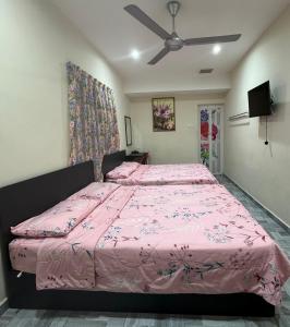 a bedroom with a pink bed and a ceiling fan at 西子楼 CZI Budget Hotel Sungai Siput in Sungai Siput
