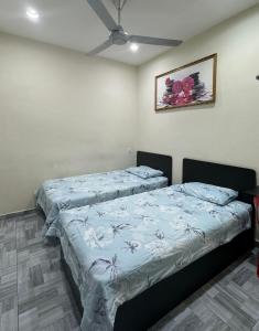 a bedroom with two beds with blue sheets at 西子楼 CZI Budget Hotel Sungai Siput in Sungai Siput