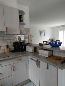 une cuisine avec des armoires blanches et des bols bleus sur le comptoir dans l'établissement Sainte Marie la mer : Villa indépendante, plage à pied à 250 m, à Sainte-Marie-la-Mer