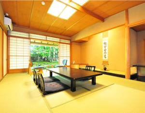 a room with a table and chairs and a window at Ryokan Imai in Shibata