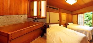 新发田市Ryokan Imai的卧室配有浴缸、床和四柱床。