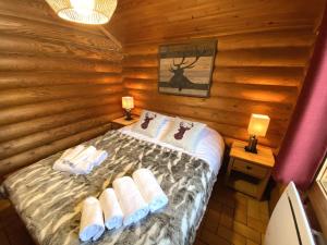 ein Schlafzimmer mit einem Bett in einem Blockhaus in der Unterkunft LE GRAND CERF Chalet en rondins avec SPA Jacuzzi in La Bresse