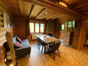 una sala de estar con sofá y mesa en una cabaña en LE GRAND CERF Chalet en rondins avec SPA Jacuzzi en La Bresse