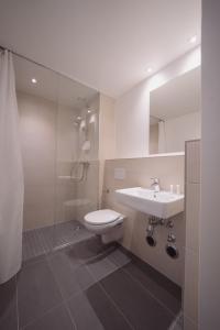 ein Badezimmer mit einem Waschbecken, einem WC und einem Spiegel in der Unterkunft NEOApartments in Berlin