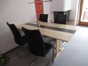 una mesa de madera con sillas negras en una habitación en Bot Sundroina (326 Sh) Whg. 2.1, en Lenzerheide