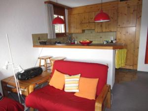 sala de estar con sofá rojo y cocina en Bot Sundroina (326 Sh) Whg. 2.1, en Lenzerheide
