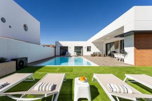 埃爾梅達諾的住宿－Villa Ikigai By Sunkeyrents，一座带游泳池和草坪的房子的图象