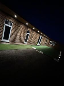 a building with lights on the side of it at night at Secret Cabin Getaway in Hartlepool