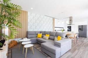 a living room with a gray couch and yellow pillows at Villa Ikigai By Sunkeyrents in El Médano