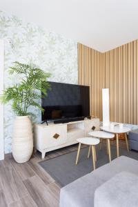 a living room with a tv and a couch and tables at Villa Ikigai By Sunkeyrents in El Médano