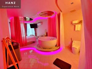 a bathroom with a tub and a large mirror at HANZ MeGusta Hotel Ben Thanh in Ho Chi Minh City