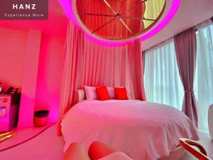 a pink bedroom with a bed and a large clock at HANZ MeGusta Hotel Ben Thanh in Ho Chi Minh City