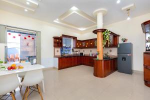 a large kitchen with a table and a refrigerator at Cát Tường Villa gần biển in Vung Tau