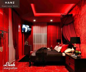 una camera rossa con letto e TV di HANZ MeGusta Hotel Ben Thanh ad Ho Chi Minh