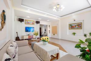 a living room with a couch and a table with flowers at Cát Tường Villa gần biển in Vung Tau