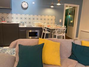 a living room with a couch and a kitchen at La parenthèse gourmande avec clim et parking in Montauban