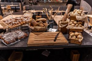 a table topped with lots of different types of pastries at Novotel Szczecin Centrum in Szczecin